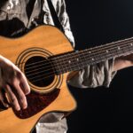 guitarist-music-a-young-man-plays-an-acoustic-guitar-on-a-black-isolated-background.jpg